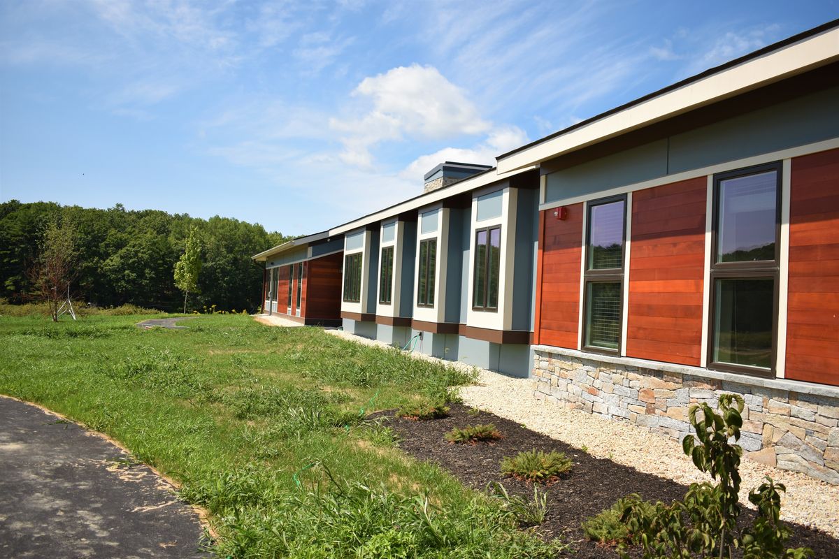A modern building with large windows and a landscaped exterior.