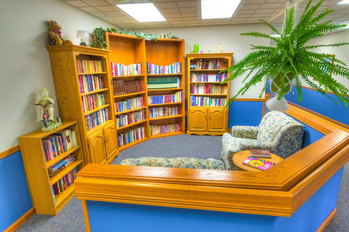 A cozy reading nook with bookshelves filled with books and a comfortable armchair.