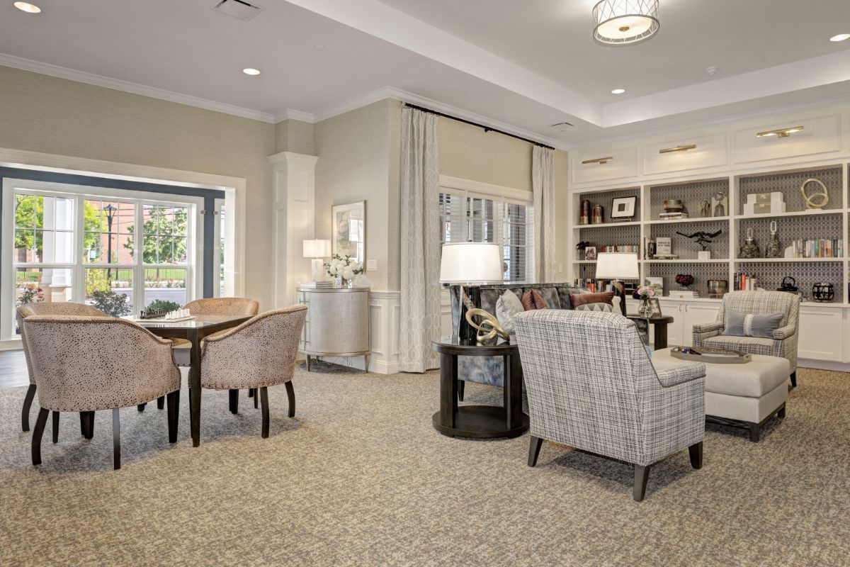 A cozy and modern living room featuring comfortable seating, a bookshelf, and elegant lighting.