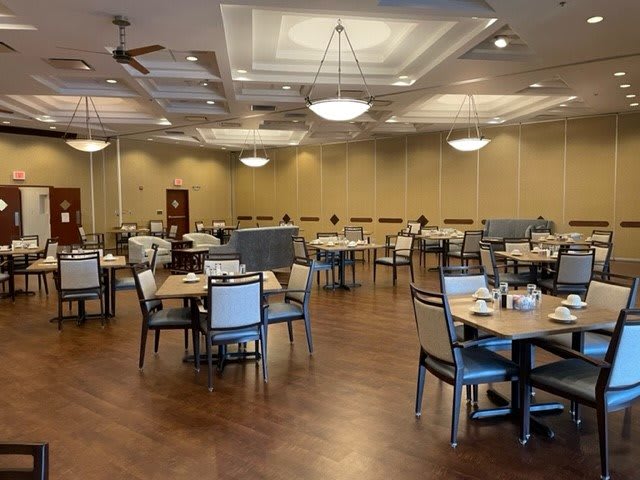 An empty dining room with neatly arranged tables and chairs, ready for guests.