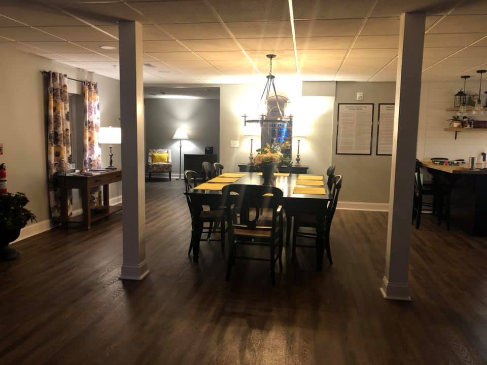 A cozy dining room setup with a table and chairs under warm lighting.