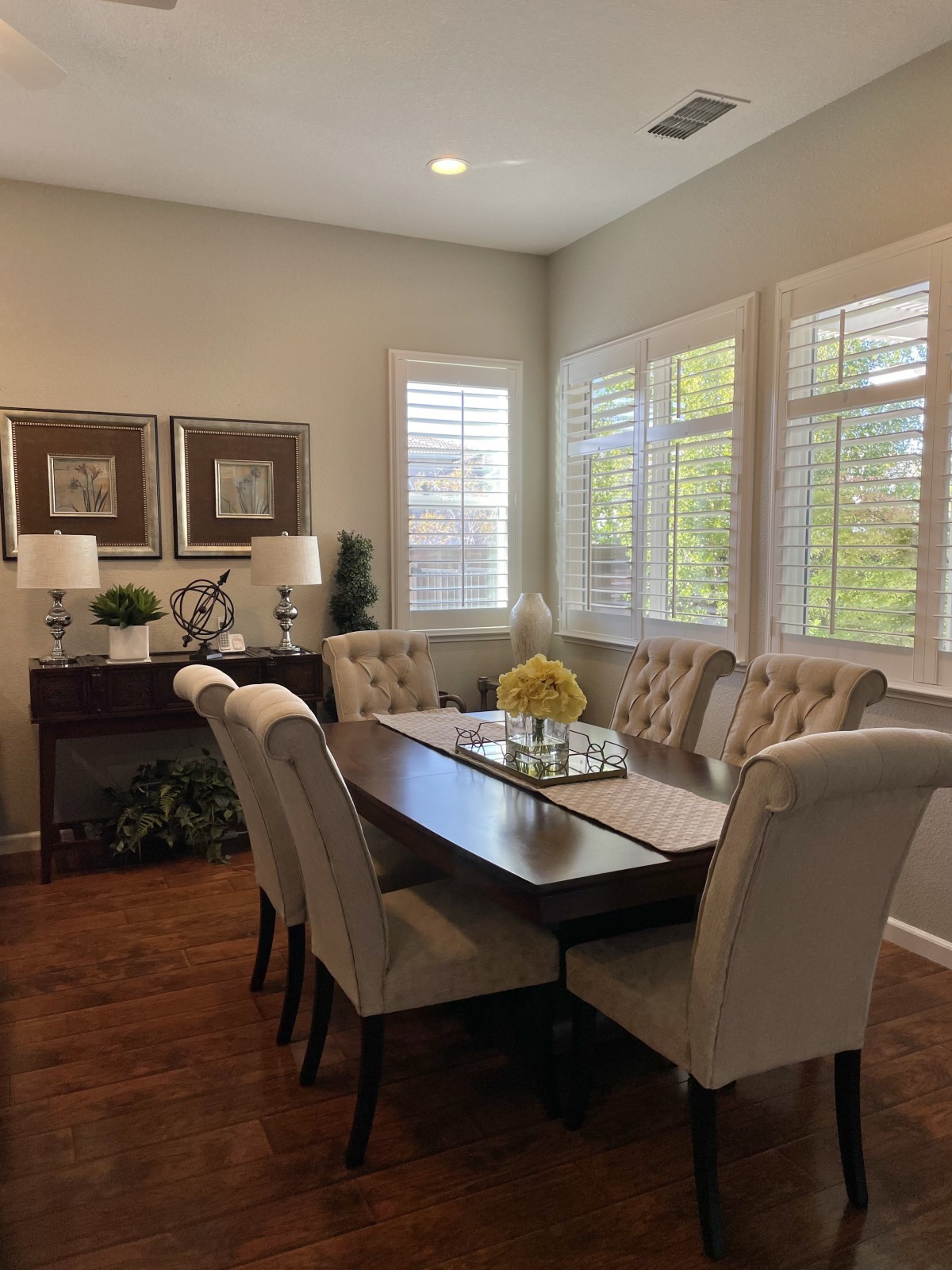 A cozy dining room with elegant furniture and ample natural light.