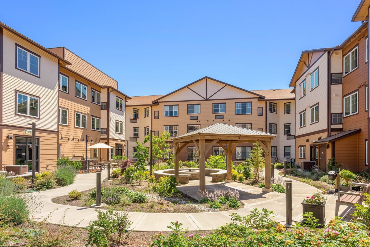 A residential building with a landscaped courtyard featuring a central gazebo.
