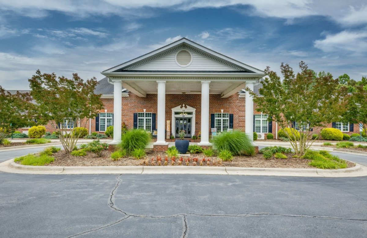 A brick building with a columned entrance and well-maintained landscaping.
