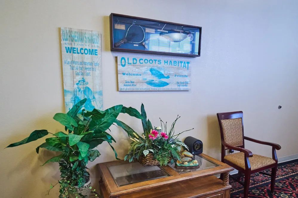 A cozy waiting area decorated with indoor plants and welcoming signs.