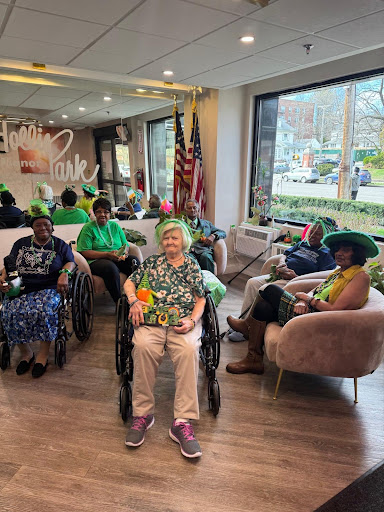 Seniors enjoying a festive community event, dressed in green and celebrating together.