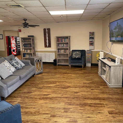 A cozy living room space featuring comfortable seating, bookshelves, and a television.