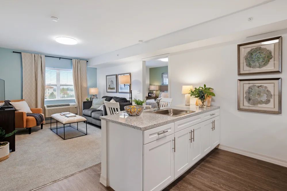 A modern open-concept living space featuring a kitchen island and comfortable seating area.