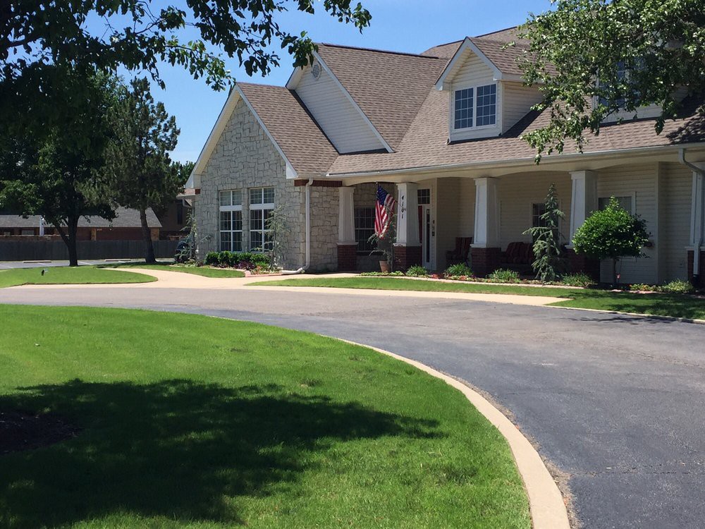 A suburban house with a well-maintained lawn and a driveway.