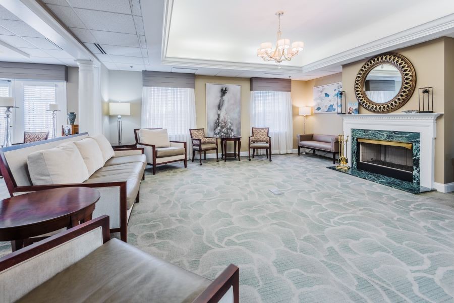 A modern waiting room with comfortable seating, a chandelier, and decorative elements.