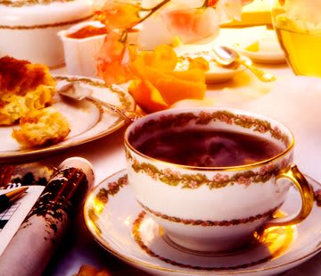 A cozy breakfast table with an elegant teacup and warm autumn decor.