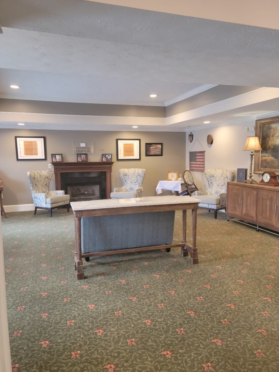 A cozy living room with a fireplace, table, and comfortable seating arrangements.