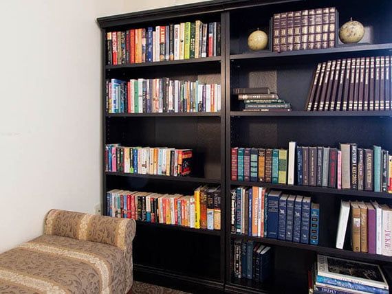 A cozy reading corner featuring a well-stocked bookshelf filled with various books.