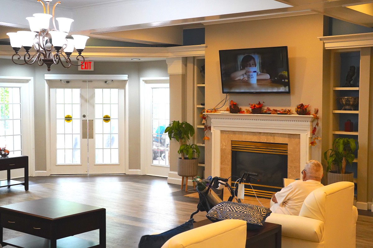 A cozy living room with a fireplace, sofa, and television.