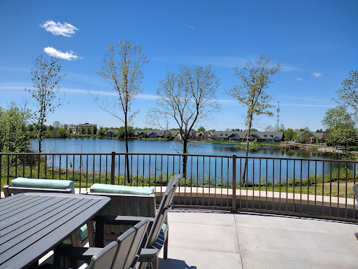 A peaceful lakeside view featuring trees and a clear blue sky, perfect for relaxation.