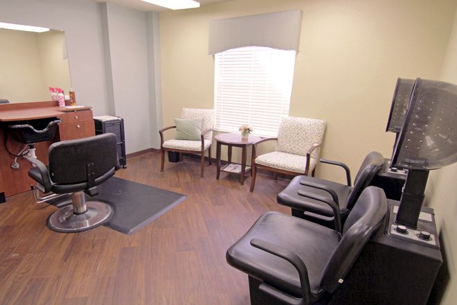 A waiting room with comfortable chairs and a small table, featuring a welcoming atmosphere.