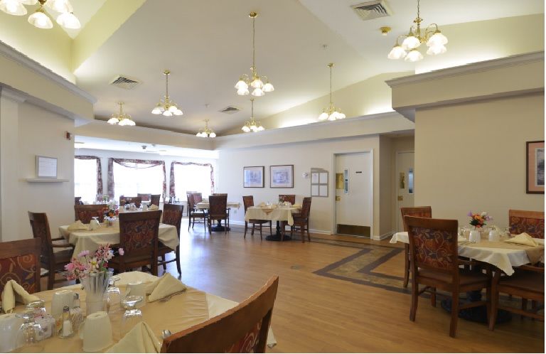 A spacious and elegantly decorated dining area with neatly arranged tables and chairs.