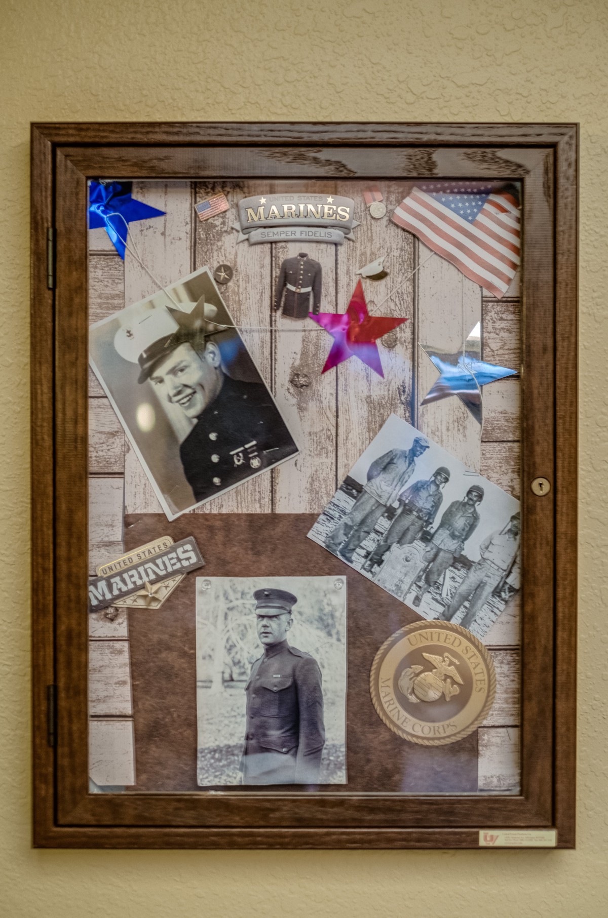 A display case showcasing vintage military photographs and memorabilia with a patriotic theme.