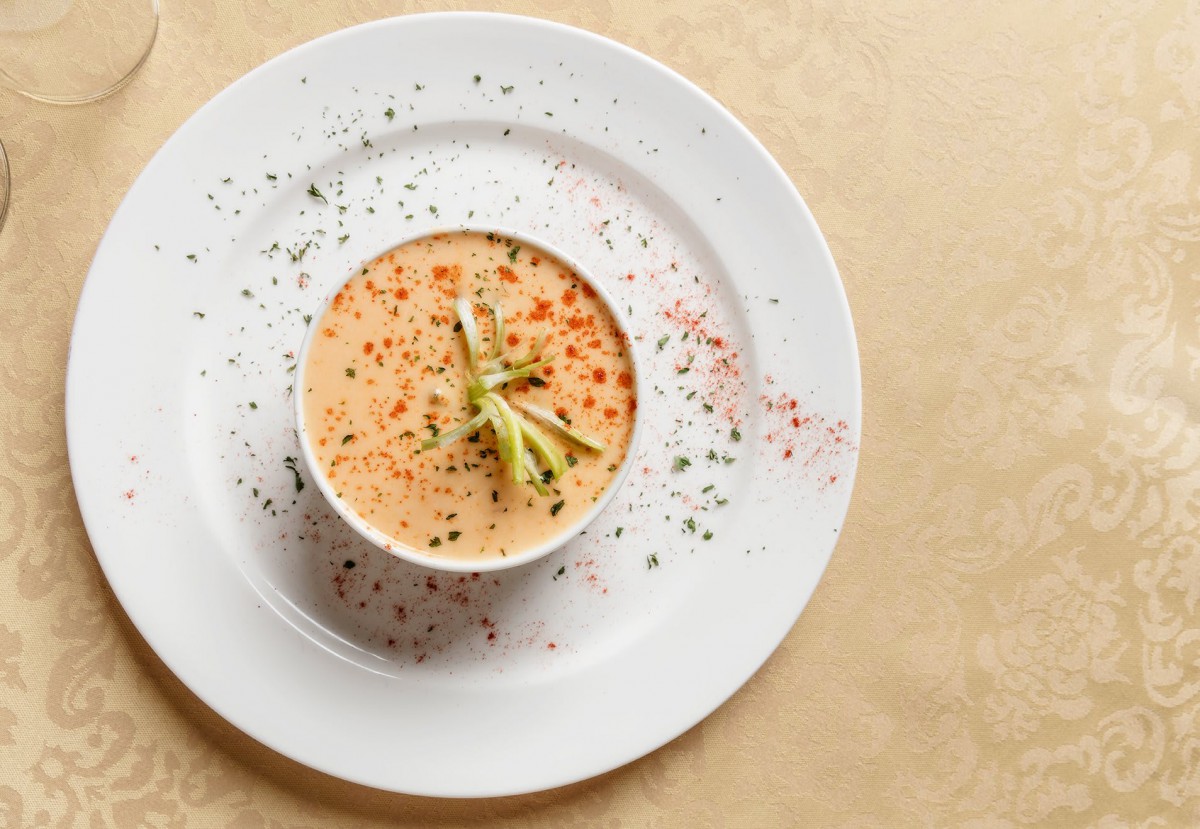 A beautifully presented creamy soup garnished with herbs and spices.