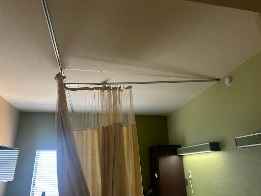 A hospital room featuring a privacy curtain hanging from a ceiling track.