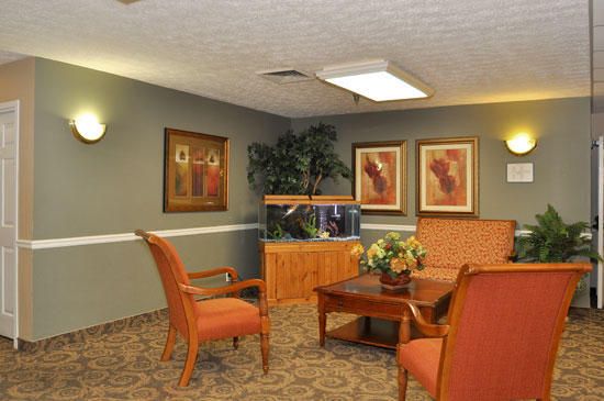 A cozy waiting room with an aquarium, comfortable chairs, and decorated walls.