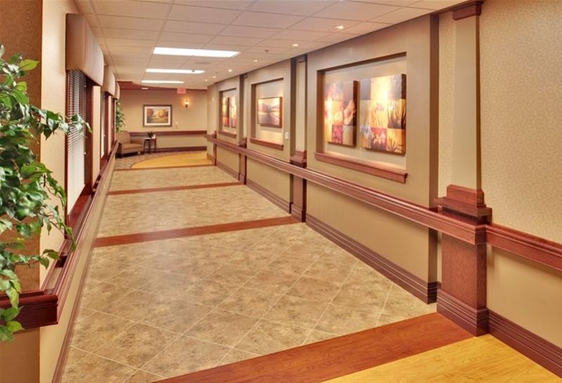 A well-lit hallway with framed artwork on the walls.
