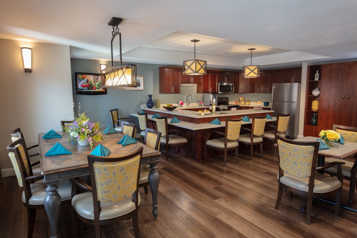 A modern open-concept kitchen and dining area featuring elegant lighting and stylish furniture.