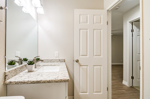 A modern bathroom featuring a stylish vanity with a sink, illuminated by soft lighting.