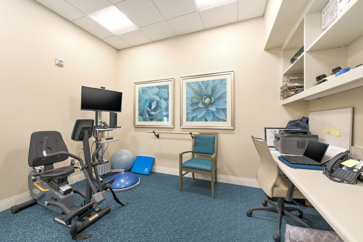 A physical therapy room equipped with various exercise machines and tools for rehabilitation.