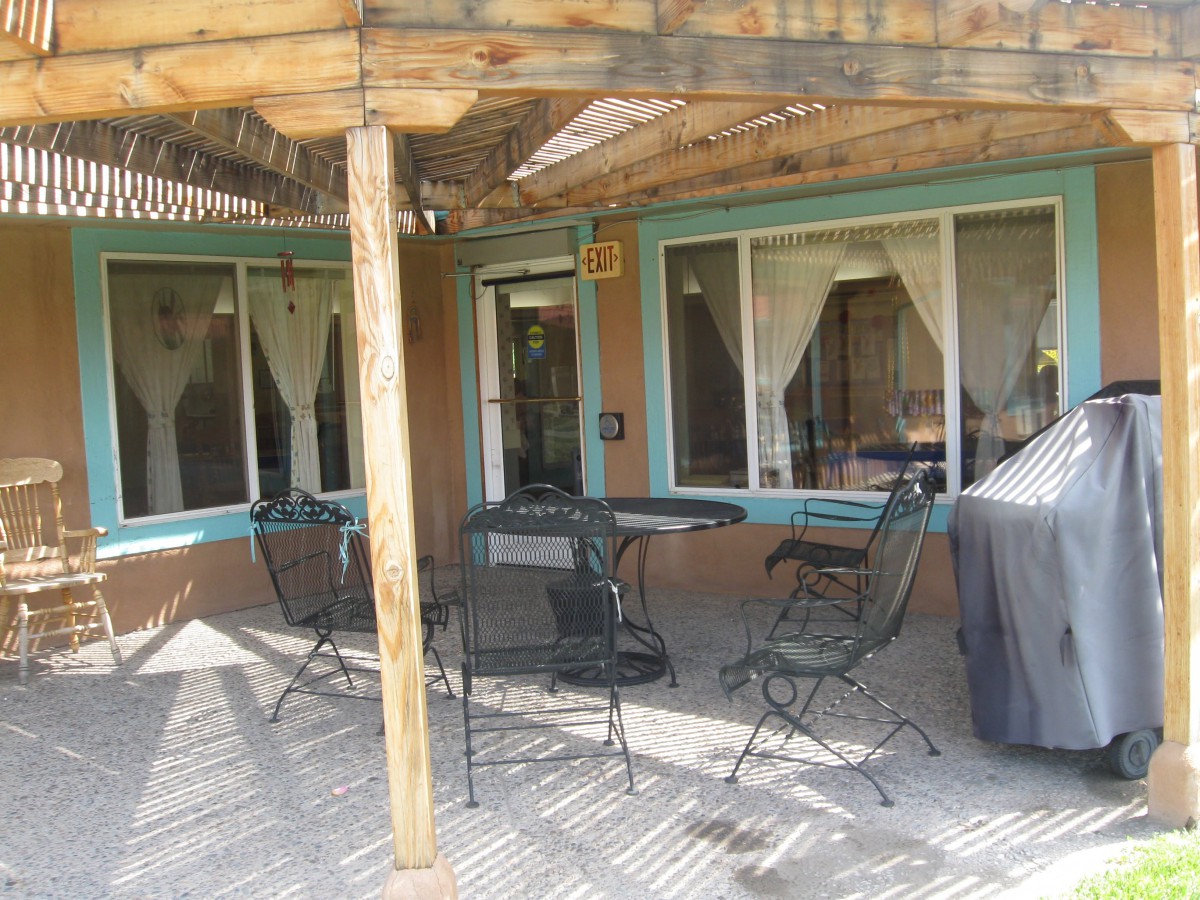 A cozy outdoor patio area with furniture under a pergola.
