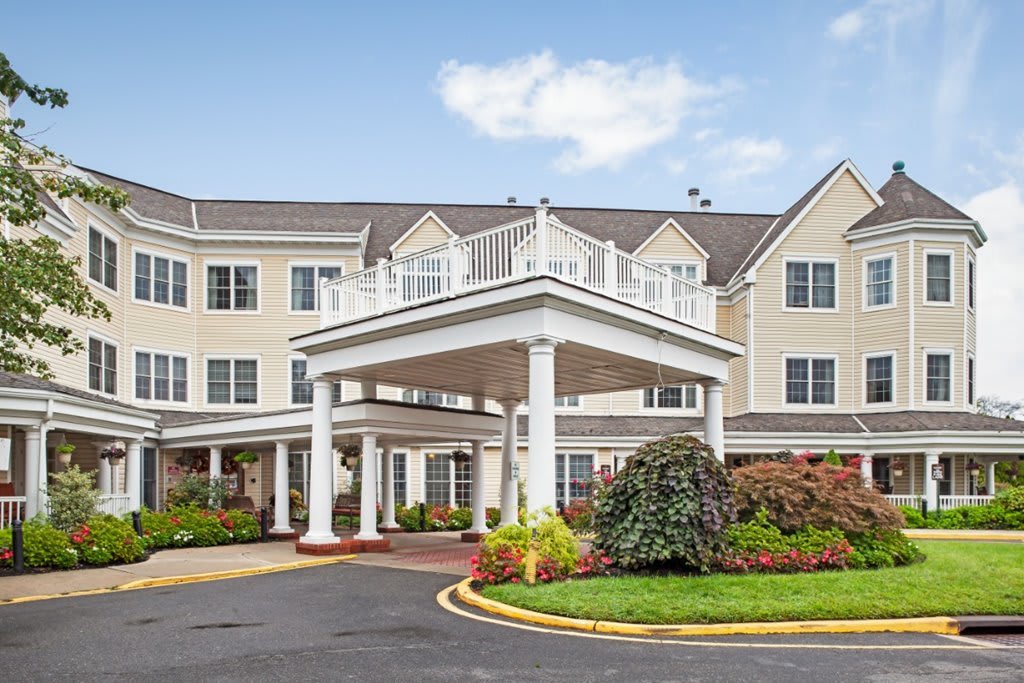A colonial-style building with a grand entrance and manicured landscaping.