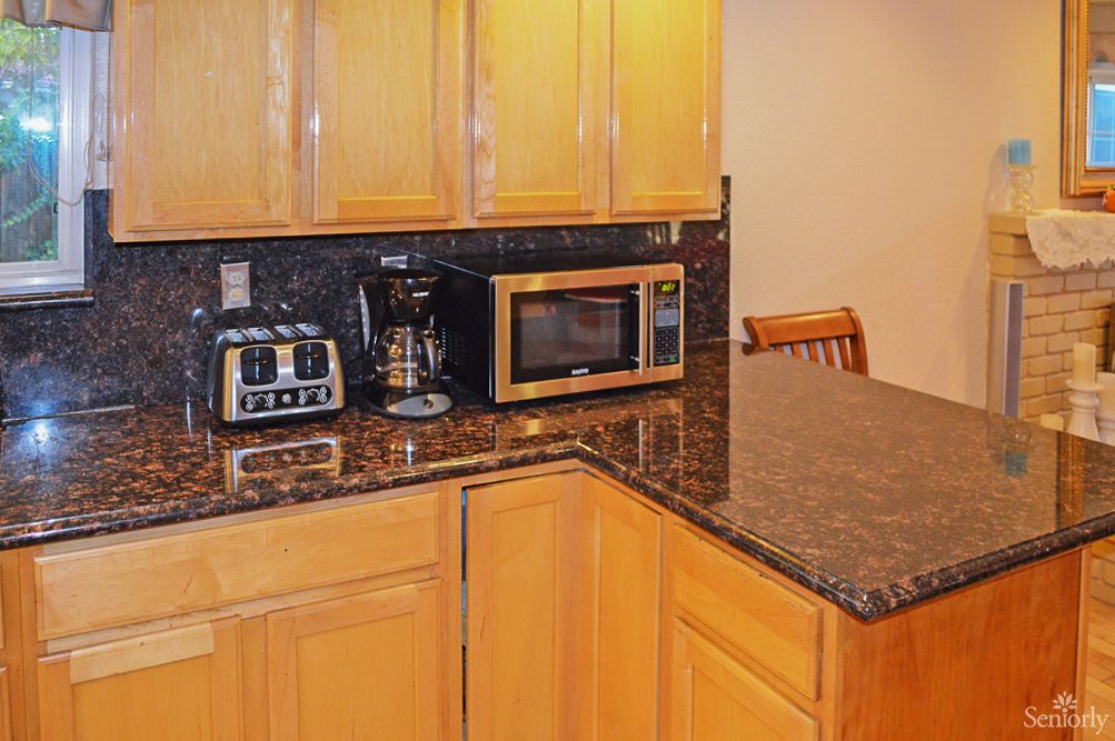 A modern kitchen countertop with a microwave, toaster, and coffee maker.