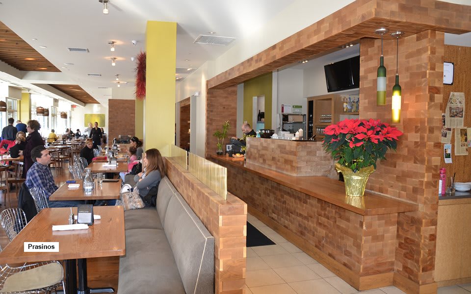 A modern restaurant interior with wooden accents, cozy seating areas, and decorative plants.