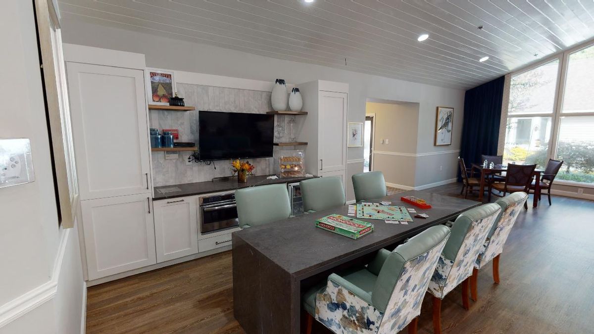 A modern living and dining area featuring a television, sleek table, and comfortable seating.