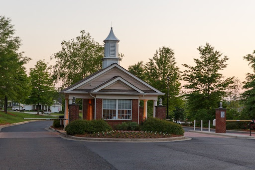 A charming entrance building surrounded by greenery, capturing the essence of a welcoming community.