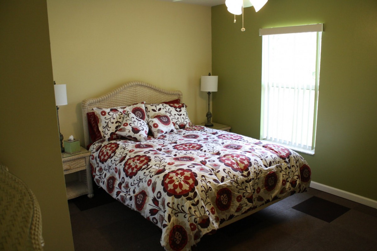 A cozy bedroom with patterned bedding and natural lighting.