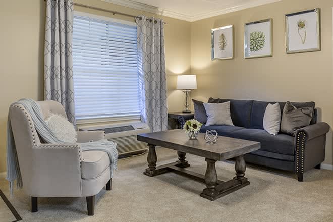 A cozy living room with a sofa, armchair, and coffee table.