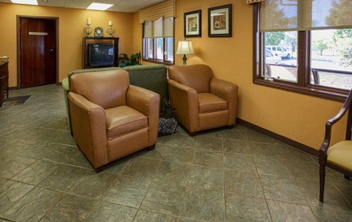 A cozy waiting room with comfortable chairs and a television.