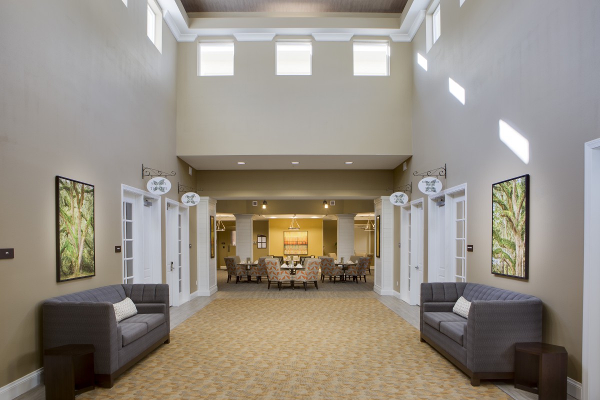 A spacious and modern lobby with high ceilings, featuring comfortable seating and bright natural lighting.