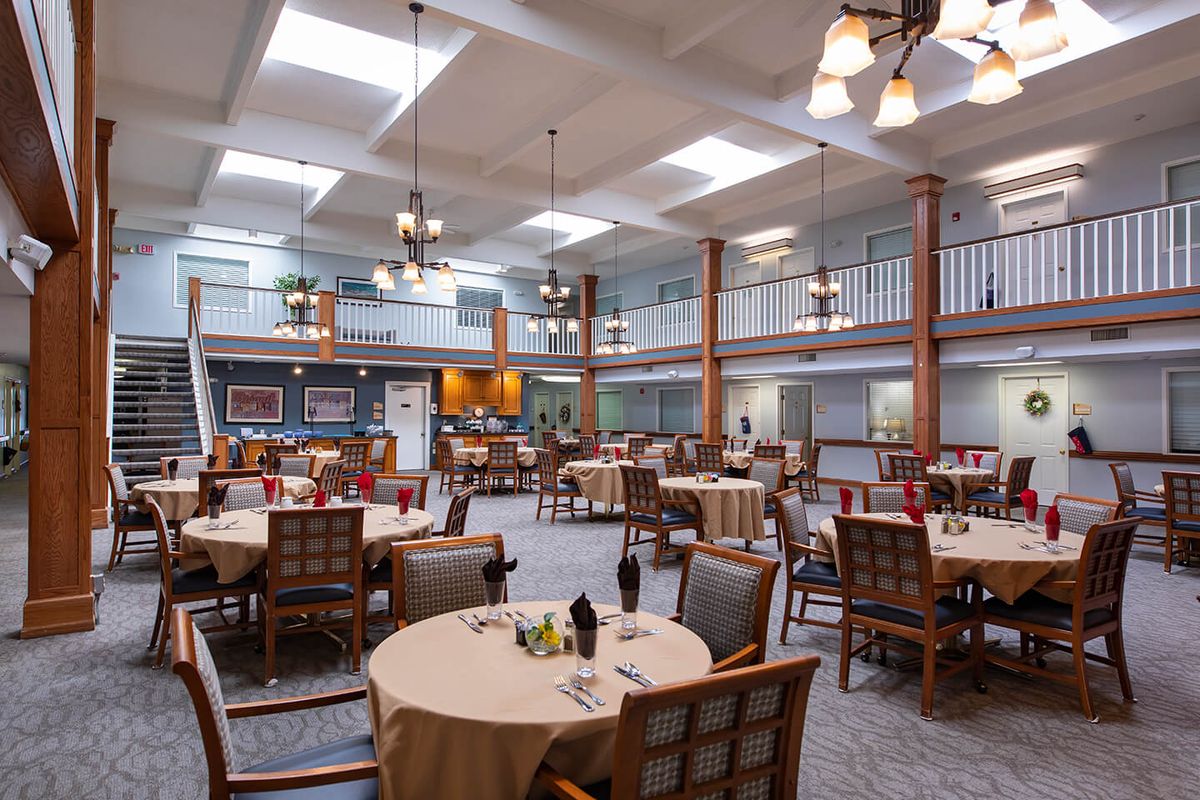 A spacious dining room with elegantly set tables and comfortable seating.