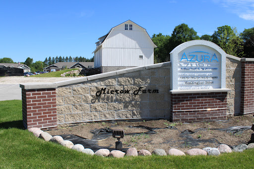 Welcome to Alexia Farm, a picturesque rural landscape featuring a charming barn and welcoming signage.