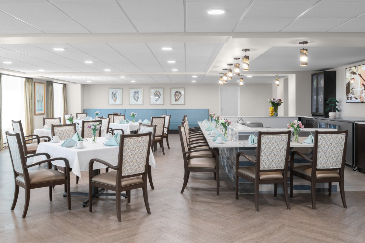 A modern and elegantly designed dining room with neatly arranged tables and chairs.