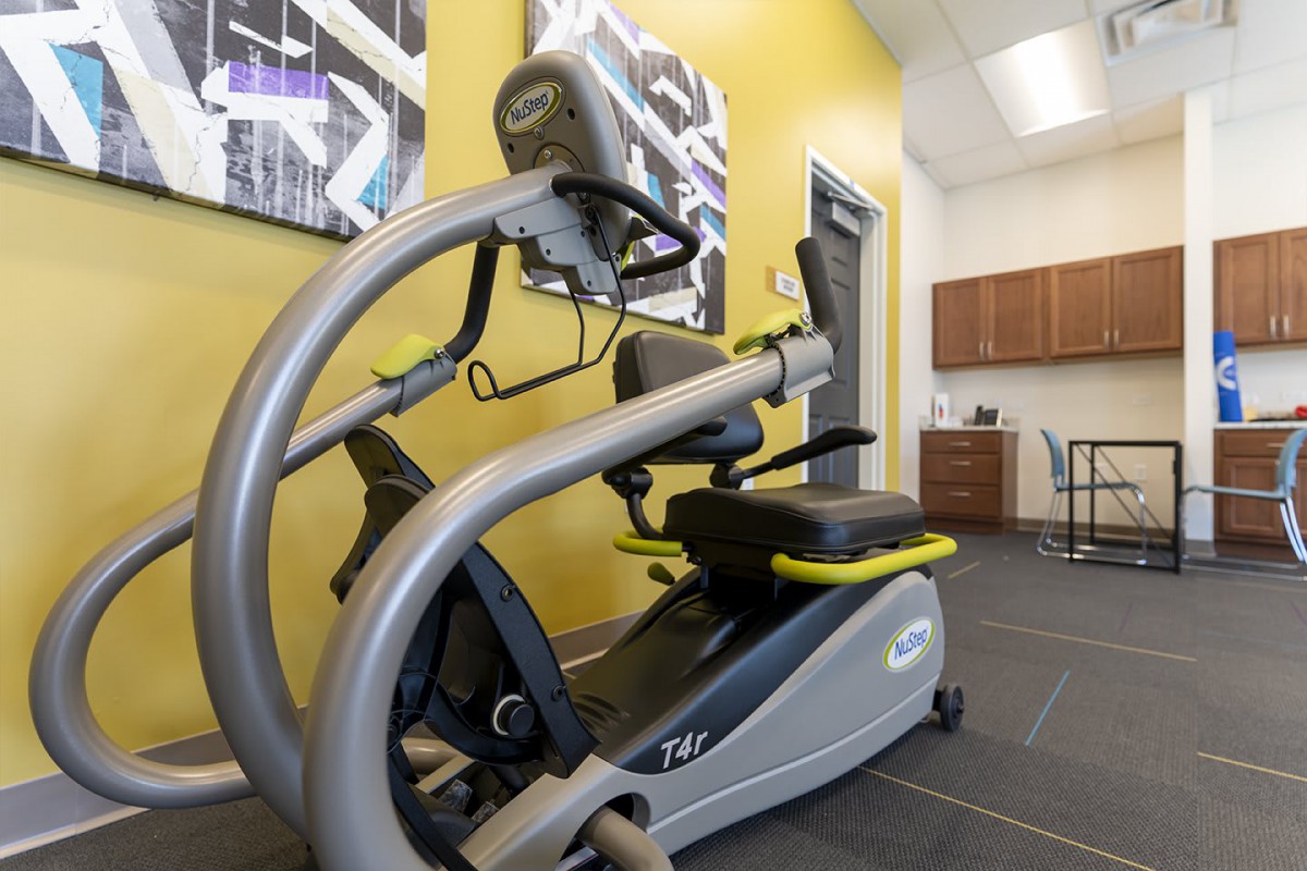 A modern exercise machine in a gym setting with yellow walls and contemporary decor.