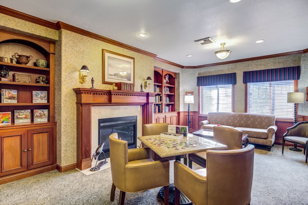 A cozy living room featuring a fireplace, bookshelves, and comfortable seating.