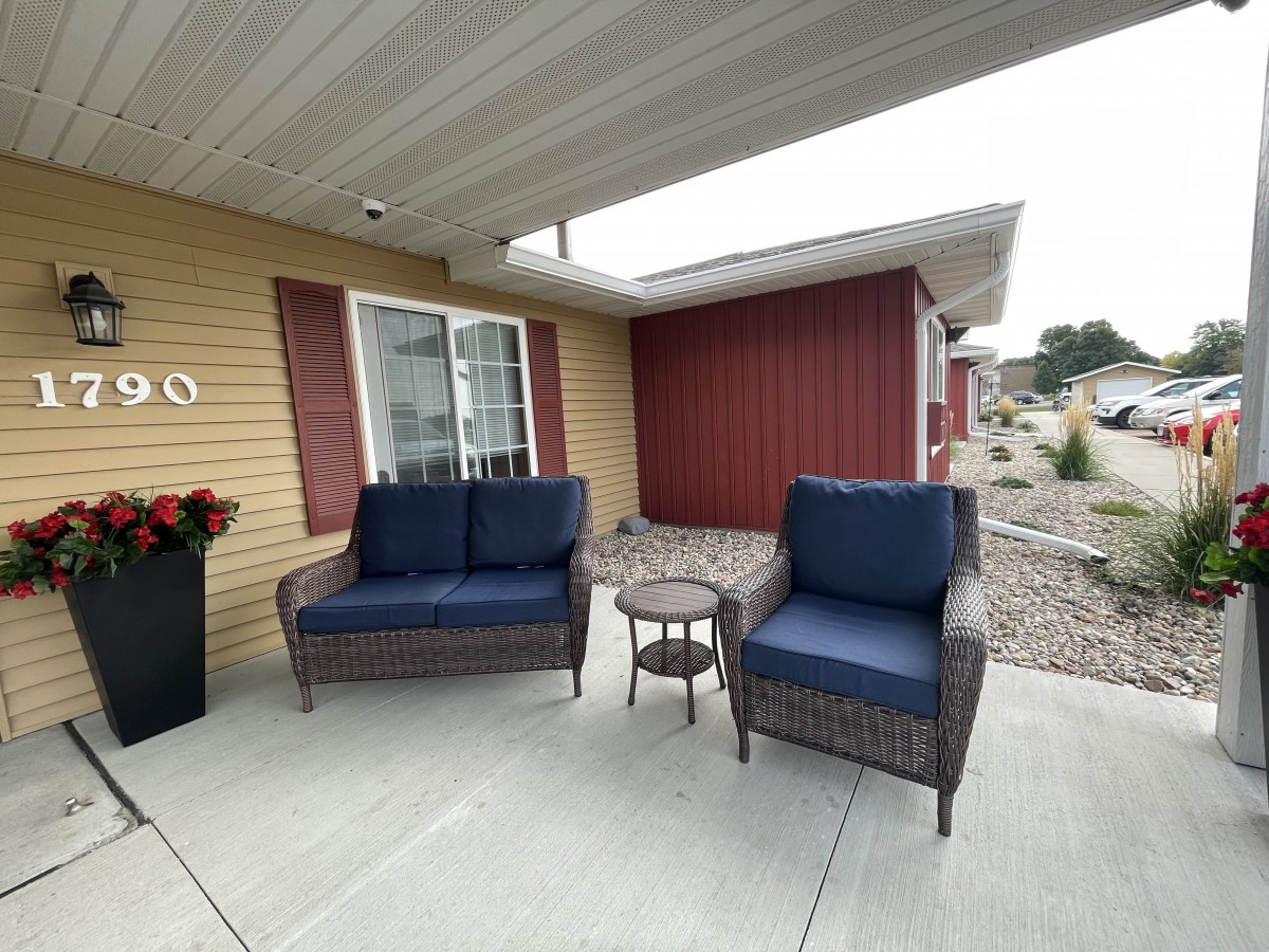 Cozy outdoor patio with a sofa, chair, and small table.