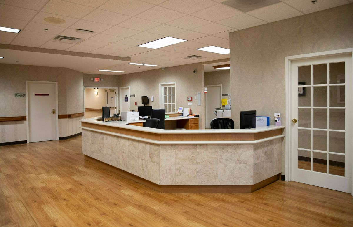 A hospital reception area with a nurse station and computers.