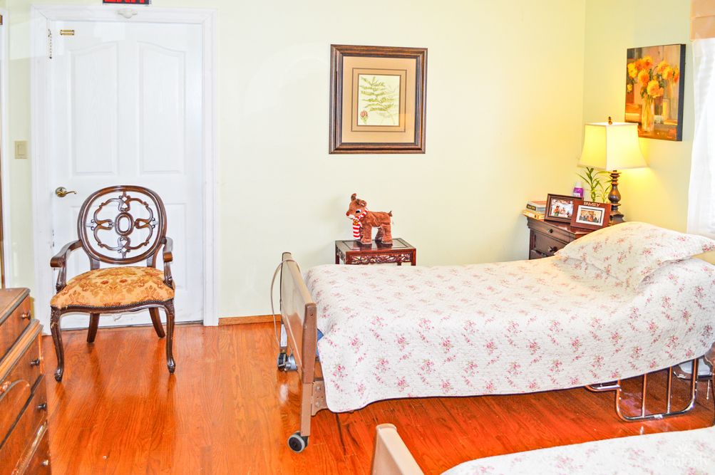 A cozy bedroom with a bed, wheelchair, and decor.