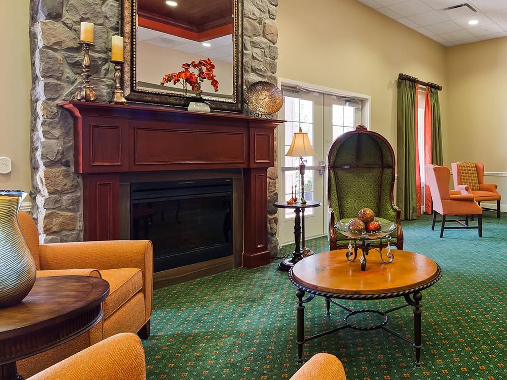 A cozy living room with a stone fireplace and comfortable seating.