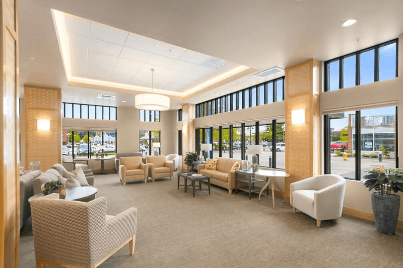 A modern waiting room with ample seating and large windows providing natural light.