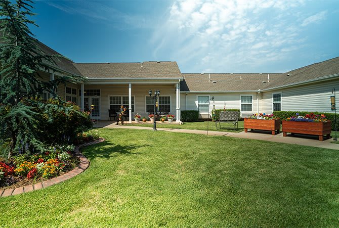 A view of a residential building with a well-maintained lawn and garden.